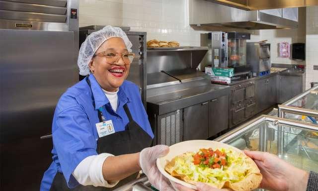 Smiling employee working in the hospital cafeteria